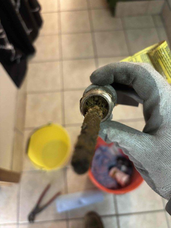 Responded to service call for leaking water heater (10+ years old, original to home). Diagnosed leak originating from stem near gas valve and found T&P valve leaking. Successfully replaced temperature and pressure relief valve to resolve immediate safety concern. Documented system condition with photos showing significant corrosion and mineral buildup in plumbing components. Recommended replacement of aging water heater and addition of expansion tank; customer will review estimate options.