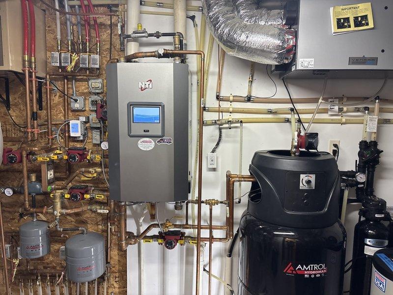 Diagnosed lukewarm water issue from NTI combi boiler system with Amtrol storage tank. Observed functional components including copper plumbing network, expansion tanks, and proper mechanical connections. Recommended customer proceed with scheduled HVAC technician consultation due to specialized nature of the NTI combi boiler system requiring manufacturer-specific expertise.