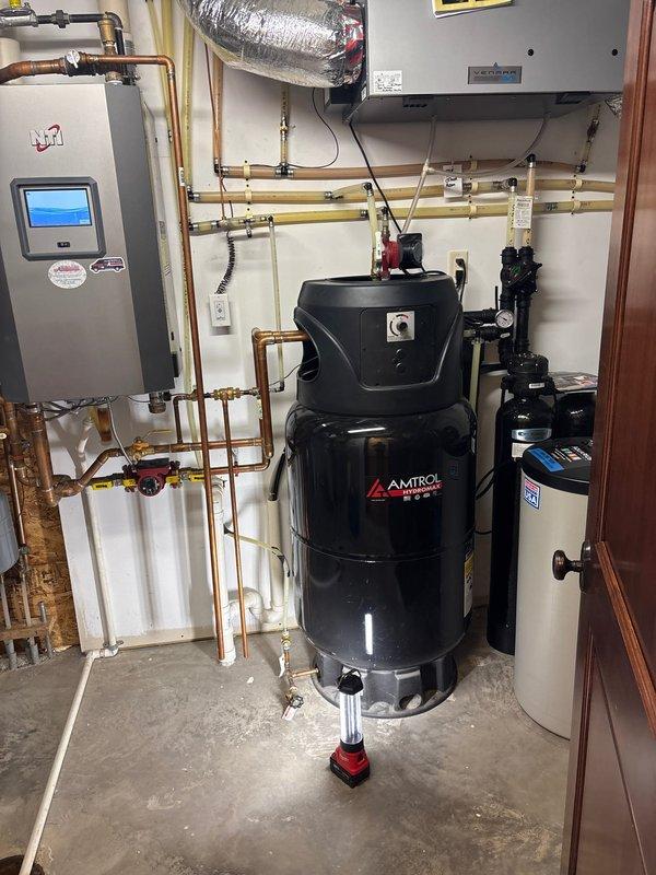 Diagnosed lukewarm water issue from NTI combi boiler system with Amtrol storage tank. Observed functional components including copper plumbing network, expansion tanks, and proper mechanical connections. Recommended customer proceed with scheduled HVAC technician consultation due to specialized nature of the NTI combi boiler system requiring manufacturer-specific expertise.