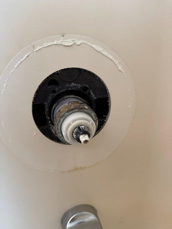 Responded to emergency service call for shower valve leak requiring complete home water shutoff. Upon inspection, found shower valve damaged from customer's attempted cartridge replacement, causing water to leak through valve body into basement ceiling. Accessed shower plumbing through wall opening and capped both hot and cold water lines to resolve the immediate leak issue.