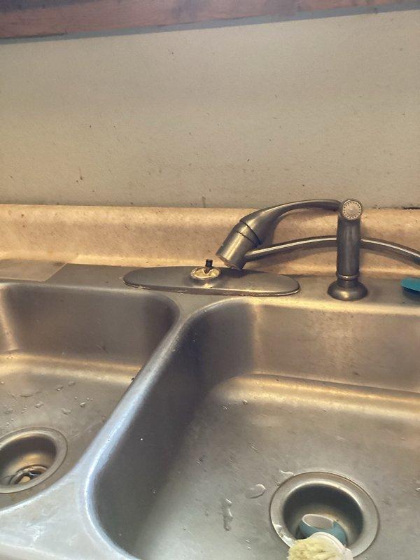 Successfully installed customer-supplied kitchen faucet in rental property after previous fixture blew off the sink. Existing water supply stops were in good working condition and were reused. Completed installation with proper under-sink connections to drainage system, though noted the provided faucet model is not ideal for rental property applications.