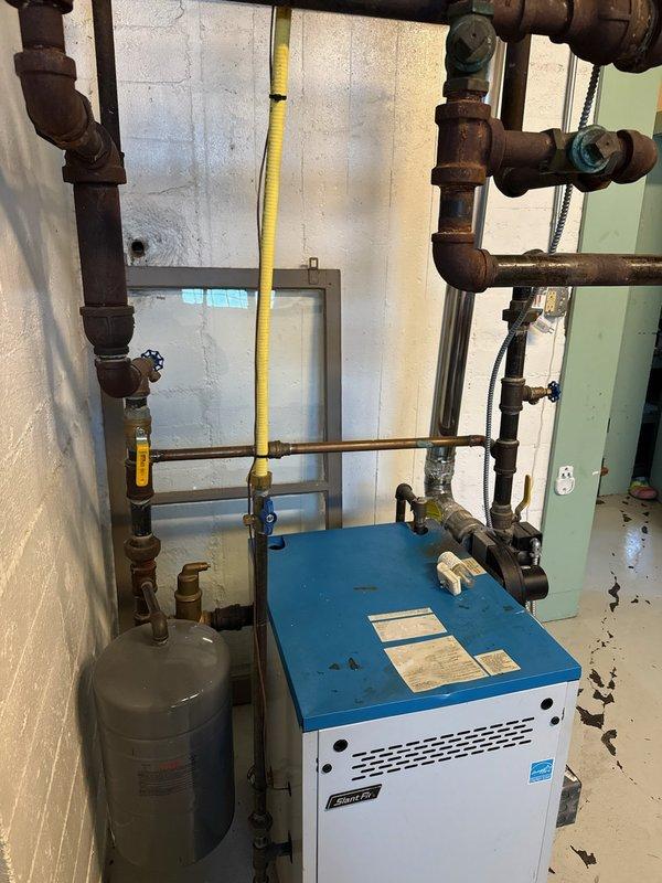 Performed routine tune-up on 20-year-old Slant/Fin water boiler. Diagnosed and addressed water leakage from relief valve caused by excessive system pressure (~30 psi). Adjusted auto fill valve, set pressure to approximately 15 psi, cleaned burners, and verified system stabilized at 18 psi when heated to 160°F. Customer advised to monitor pressure, with possible future expansion tank or relief valve replacement if issues persist.