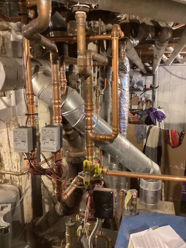 Diagnosed non-operational boiler exhibiting pilot ignition but no main burner ignition. Performed troubleshooting including water pressure verification, zone valve inspection, and system jumpering. Identified faulty gas valve producing buzzing noise during operation. Replaced gas valve, confirmed proper pilot operation, and adjusted gas pressures to specifications. System successfully restored to normal heating operation.