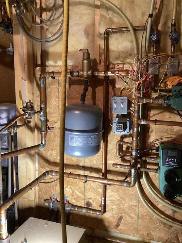 Responded to a service call for an in-floor heating system powered by a 19-year-old boiler with diminished heating performance. Diagnosed low water pressure causing system shutdown, restored pressure, and performed comprehensive system check of zone valves, manifolds, pumps, and controls. Identified damaged control board on radiant heat mixing block and noisy air handler relay pump; flushed discolored water from loops and temporarily restored boiler operation while preparing estimate for necessary component replacements including sensors.