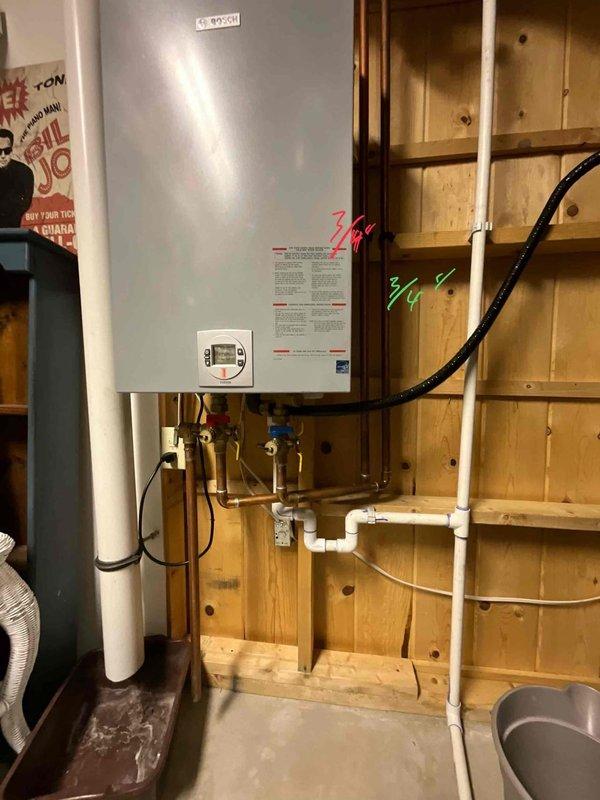 Completed estimate for tankless water heater replacement. Inspected existing installation and proposed new wall-mounted unit. Customer approved proposal for tankless system with PVC venting and copper supply connections, to be installed on wooden wall in utility area.