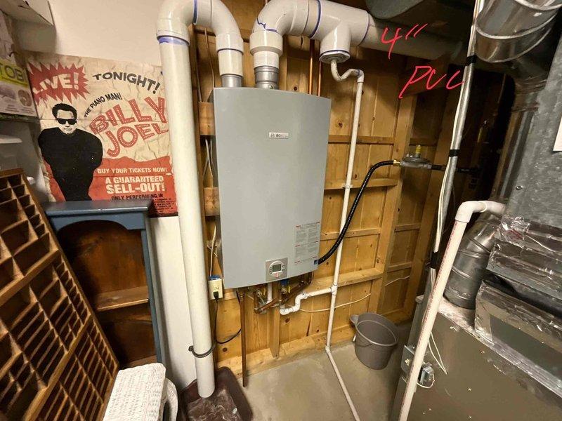 Completed estimate for tankless water heater replacement. Inspected existing installation and proposed new wall-mounted unit. Customer approved proposal for tankless system with PVC venting and copper supply connections, to be installed on wooden wall in utility area.