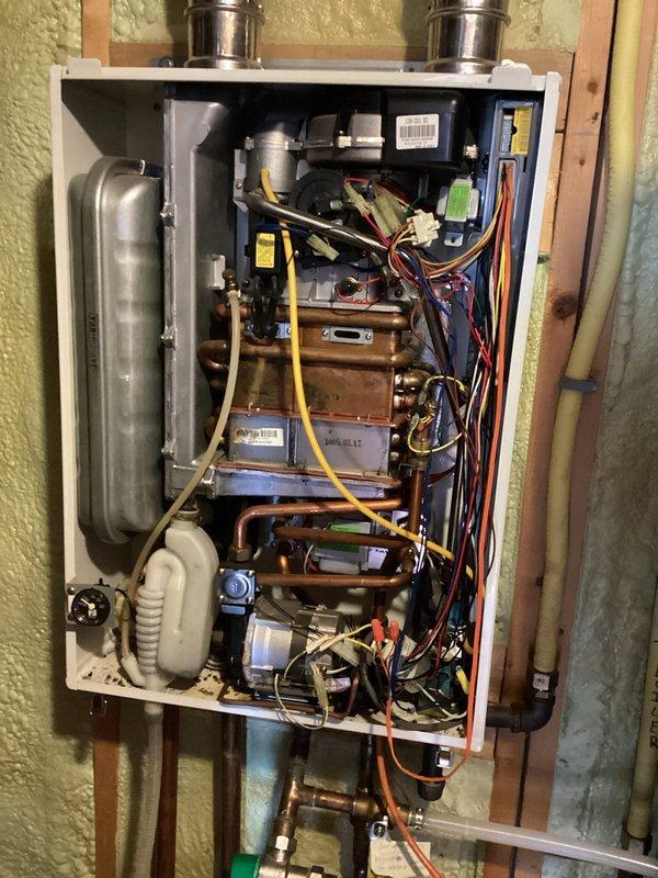 Diagnosed and repaired Navien boiler showing error code 13 (heating flow switch fault). Found defective flow sensor valve assembly causing intermittent operation failure after 8-12 hours of run time. Replaced flow switch assembly and verified proper system operation with no additional fault codes during extended test cycle.