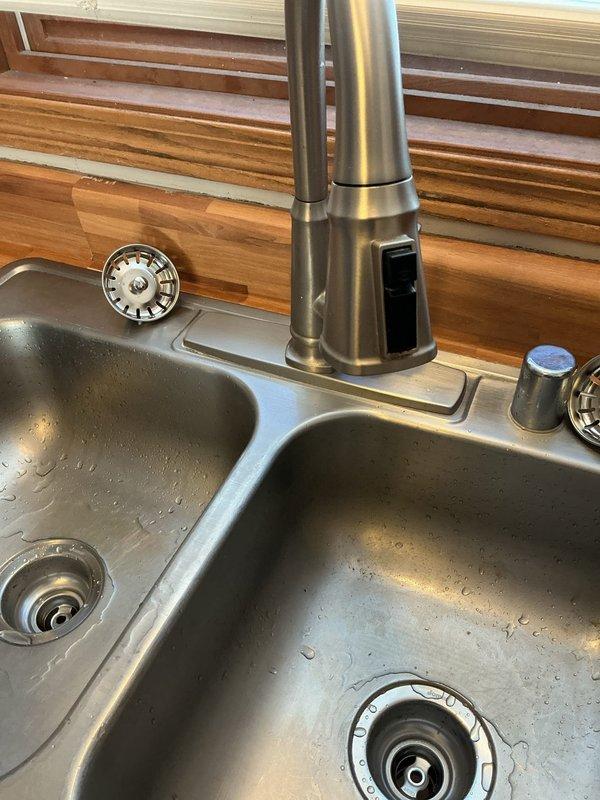 Completed replacement of kitchen sink plumbing assembly, including installation of new drain pipes and fittings throughout the under-sink area. Reinstalled double-basin stainless steel kitchen sink with existing faucet and accessories. All connections were secured with proper clamps and tested for leaks to ensure proper function.