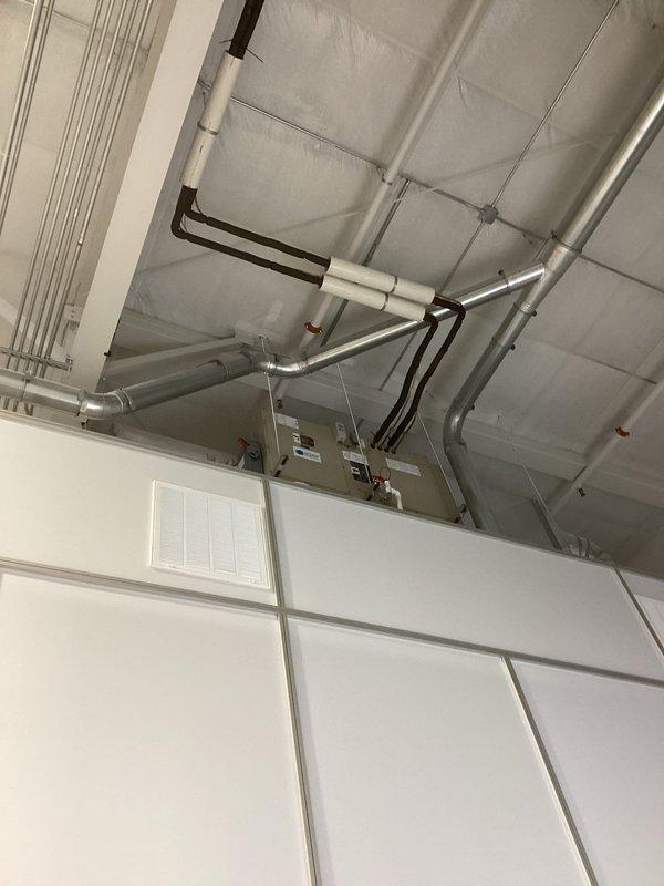 Responded to customer complaint of clean room not cooling properly with temperature rising to 74°F. Upon arrival, room temperature had already decreased to 69°F matching thermostat setpoint. Inspected both HVAC units serving the clean room and found them operating normally with clean outdoor coils. Pressure tested both systems and found similar readings, though cold outdoor conditions made precise diagnosis difficult. Unable to identify definitive issues with either unit. Advised customer that further diagnosis would require assessment during warmer weather conditions, but confirmed units are currently operational with no visible ice formation.