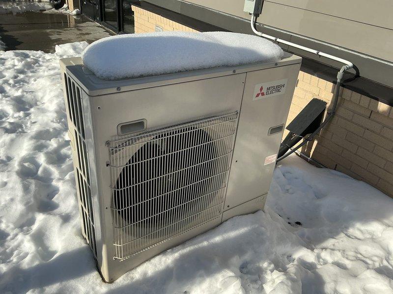 Responded to customer complaint of Mitsubishi mini split system not maintaining setpoint temperature (set at 72°F but only reaching 60°F). Upon inspection, found outdoor condensing unit completely buried in snow, preventing proper heat exchange and system operation. Cleared snow accumulation from unit and surrounding area to restore proper airflow. System tested after snow removal and confirmed fully operational with normal heating function restored.