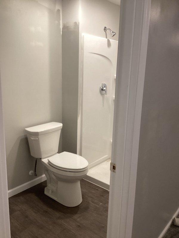 Completed installation of standard height toilet in bathroom renovation project after customer's flooring work was finished. Successfully connected water supply to existing rough-in plumbing and verified proper operation. Shower/tub installation remains pending customer's completion of vanity and countertop placement.