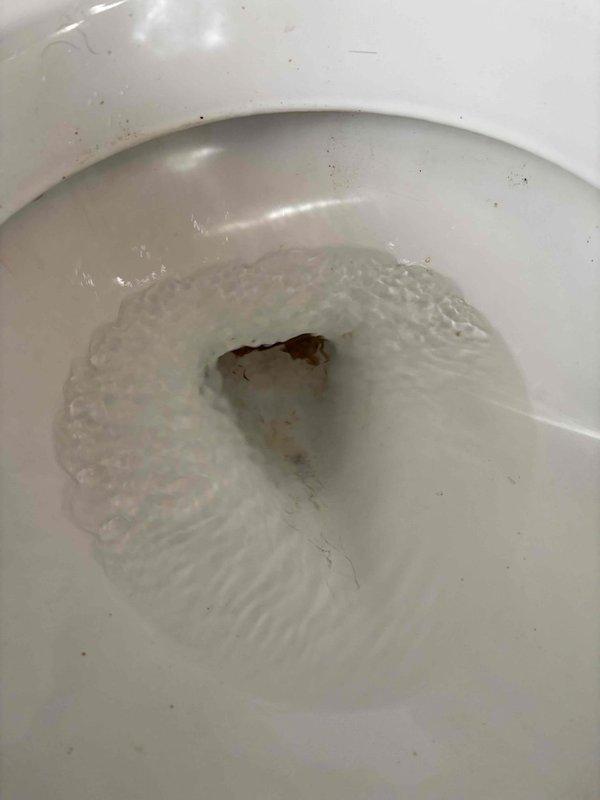 Cleared clogged toilet caused by significant calcium buildup resulting in semi-hard blockage. Successfully restored proper drainage using auger. Advised customer on toilet replacement options due to mineral accumulation affecting performance.