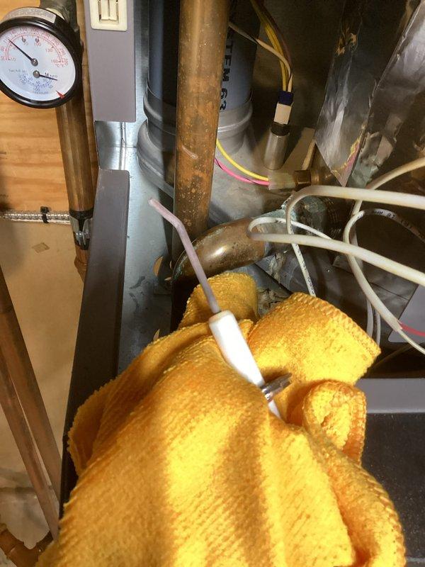 Diagnosed boiler operating abnormally with flame fluctuations and vibration noise at intake pipe. Inspection revealed damaged ignitor at spark point and internal damage to the Venturi damper section affecting airflow and causing noise. Ordered replacement parts including ignitor, flame sensor, and gas valve assembly with attached Venturi.