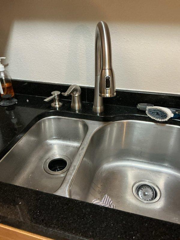 Successfully installed customer-supplied kitchen faucet with pulldown sprayer in double-basin sink, completing proper connection to supply lines and drain assembly. Also installed two additional bathroom faucets and replaced two showerheads as requested, ensuring all fixtures were properly sealed and functioning correctly before departure.
