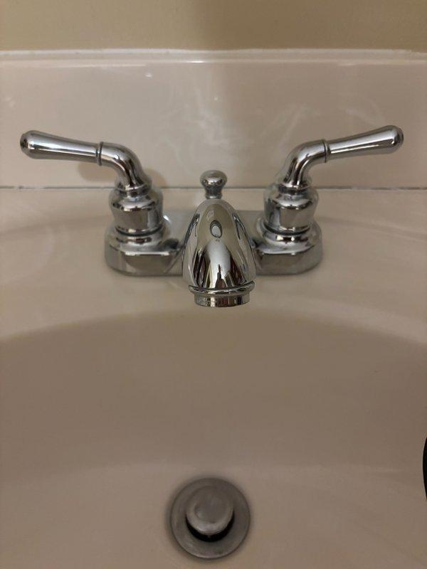 Responded to service request for leaky bathroom faucet issue. Diagnosed faulty cartridge as the source of the leak. Presented customer with options to either replace the cartridge or install new faucet fixtures. Customer opted for complete replacement; installed new polished chrome faucet with dual lever handles on existing vanity sink.
