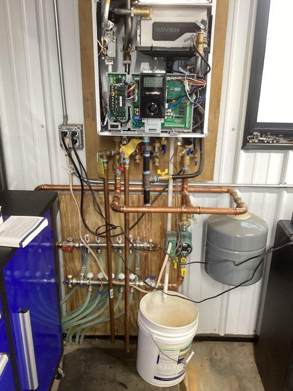 Responded to service call for Navien boiler system experiencing ignition failure. Diagnosed issue as inadequate gas pressure for high-fire operation on the current low-pressure LP system. Connected outdoor temperature sensor as temporary measure to reduce high-fire cycling. Customer will coordinate with LP provider to upgrade to required 2 PSI system. Return visit scheduled to install maxitrol regulator once gas company completes system upgrade.