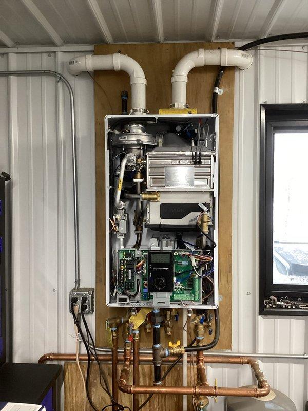 Responded to service call for Navien boiler system experiencing ignition failure. Diagnosed issue as inadequate gas pressure for high-fire operation on the current low-pressure LP system. Connected outdoor temperature sensor as temporary measure to reduce high-fire cycling. Customer will coordinate with LP provider to upgrade to required 2 PSI system. Return visit scheduled to install maxitrol regulator once gas company completes system upgrade.