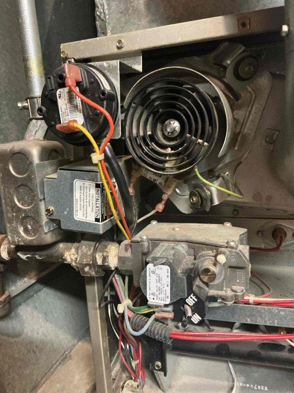 Responded to service call for an 18-year-old Carrier furnace experiencing intermittent operation with error codes 12, 13, and 33. Diagnostic inspection revealed draft inducer motor with failing bearings causing squealing and scraping noises, oil leakage from blower motor, out-of-spec blower capacitor, and high limit switch activation despite low temperature readings (approximately 120°F). Heat exchanger inspection showed no cracks but significant temperature stress and rust formation. Reviewed replacement options with homeowner due to multiple component failures and age of system.