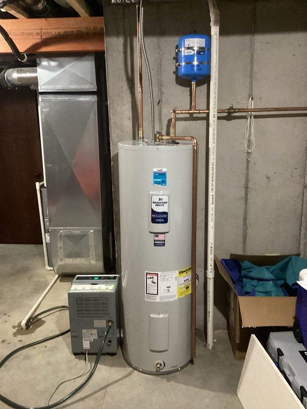 Replaced non-functioning electric water heater with a new 50-gallon Bradford White model after diagnosing a bad lower element and upper thermostat on the original 10-year-old unit. Installation included proper connection to existing copper piping and blue expansion tank mounted on the wall.