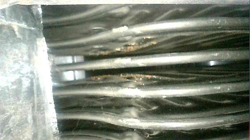 Serviced 15-year-old forced air furnace that was shutting down due to limit switch activation. Diagnostic inspection revealed clogged secondary heat exchanger with visible corrosion and buildup on the heat exchanger fins. Replaced secondary heat exchanger to resolve high CO issue and restore normal system operation.