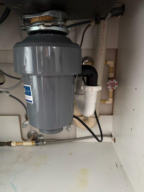 Responded to plumbing service call for multiple issues: repaired leaking CPVC fitting at meter, replaced damaged dishwasher drain hose that was causing under-sink leakage, and inspected garbage disposal system. Customer was informed about recommended dishwasher replacement.