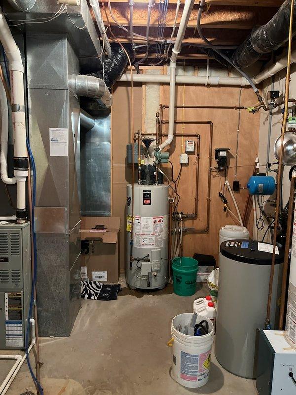 Diagnosed leaking in-floor heating system water heater, discovering internal rust and water leaking onto burner assembly. Powered up unit to verify leak source and determine system condition. Deactivated water heater as customer has furnace for primary heating; discussed replacement options including potential conversion to tankless system to replace both existing water heaters.