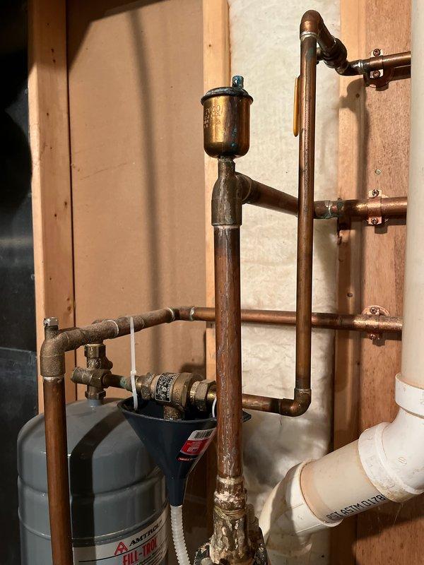 Diagnosed leaking in-floor heating system water heater, discovering internal rust and water leaking onto burner assembly. Powered up unit to verify leak source and determine system condition. Deactivated water heater as customer has furnace for primary heating; discussed replacement options including potential conversion to tankless system to replace both existing water heaters.