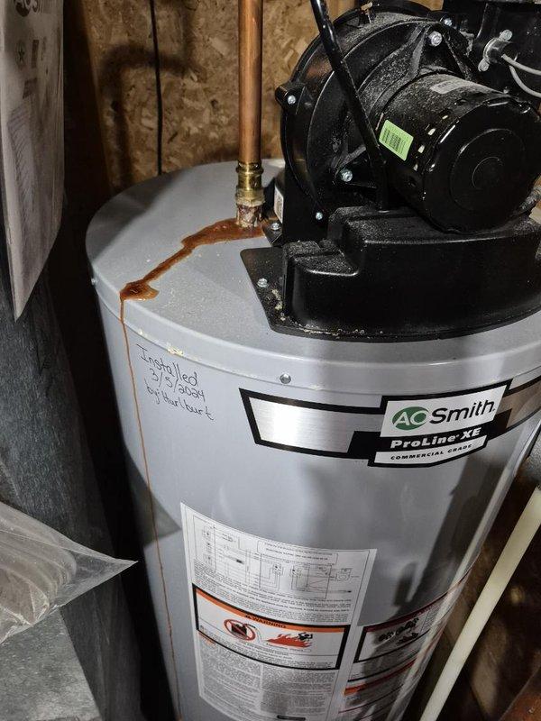Replaced leaking 40-gallon LP water heater that showed significant corrosion at connection points. Installed new A.O. Smith ProLine XL commercial series water heater with proper copper piping and fittings, resolving the water leakage issue.