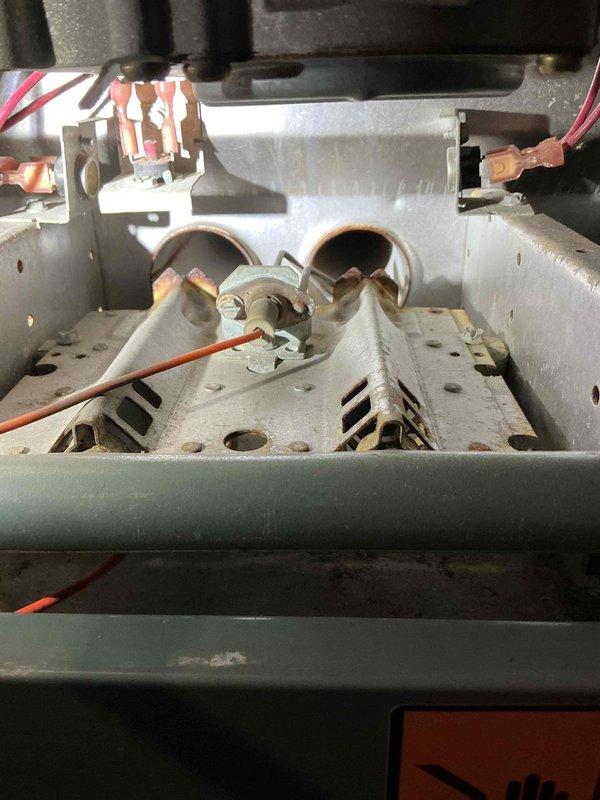 Responded to no-heat service call for 23-year-old Ruud Silhouette II furnace. Diagnosed seizing blower motor causing squealing/rattling noise during operation, confirmed by manual rotation test showing immediate stoppage. Inspection revealed extensive heat exchanger damage including pinholes in tubes, developing crack at right burner entry, and severely rusted burners requiring replacement. Scheduled service advisor visit for system replacement options.