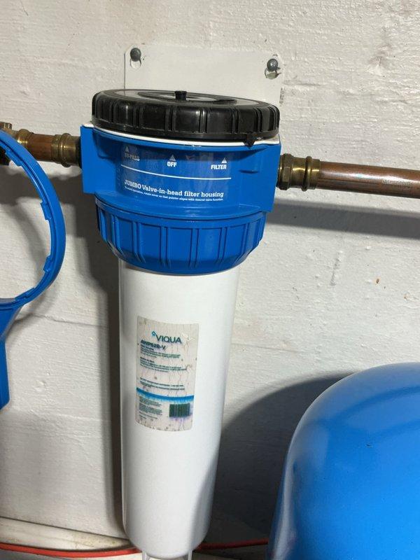 Performed annual service on customer's water treatment system, replacing the iron filter cartridge in the VIQUA filtration unit. Removed old iron filter media, properly disposed of waste material, and installed new filter. System functioning properly after service completion.