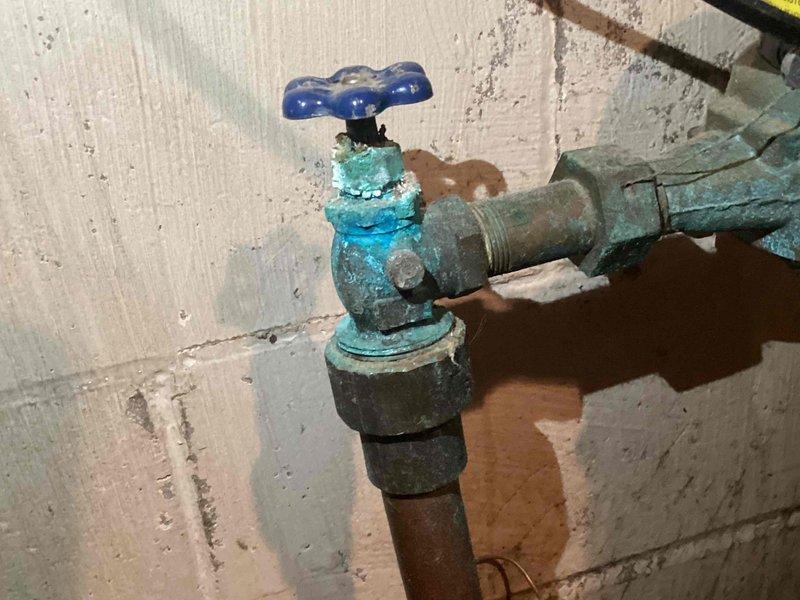 Responded to service call for leaking kitchen faucet. Diagnosed severe corrosion on fixture, particularly on valve body which displayed extensive oxidation and blue-green patina. Completed temporary repair of the faucet, but advised customer that replacement is recommended due to age and deteriorated condition of the unit and associated components.