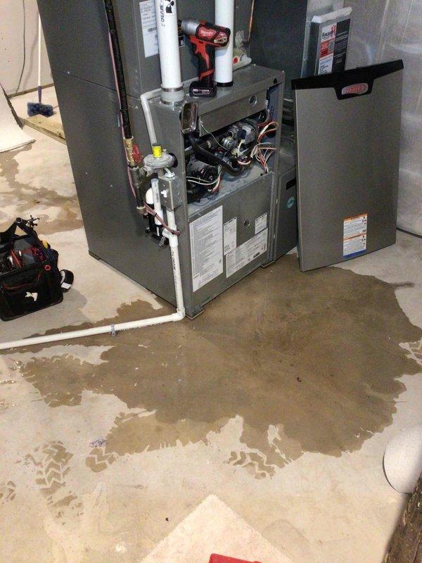 Responded to warranty service call for condensate drainage issue on newly installed furnace. Diagnosed water leak originating from condensate line where water was rolling back from drain due to improper fit. Modified the elbow fitting with tin snips to properly fit the small floor drain, then glued it in place to ensure correct drainage path. Cleaned up accumulated water from the floor.