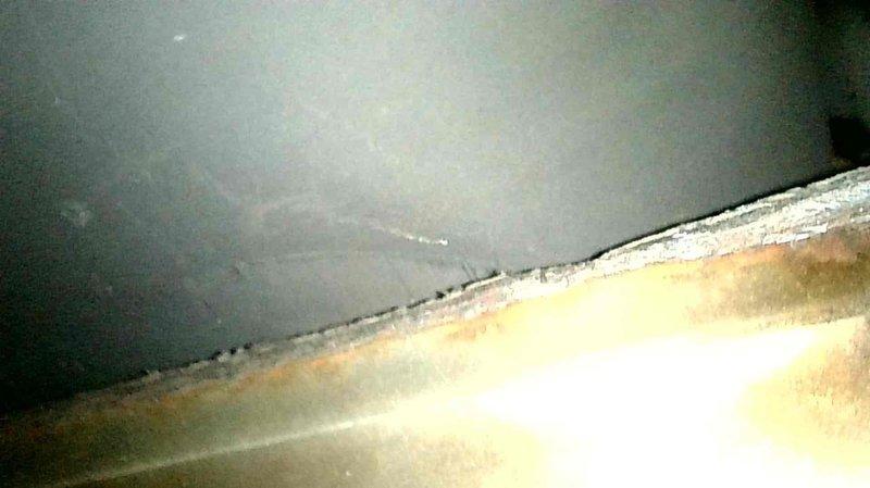 Responded to service call for a 16-year-old oil furnace exhibiting smoke at the injector and continuous fan operation. Inspection revealed improper ductwork modification with return air opening directly above the exhaust baffle, causing minor sooting. Heat exchanger was intact with no internal damage. Replaced nozzle, verified proper system function, and advised customer to relocate the return air opening further downstream and properly seal existing ductwork to prevent recurrence.