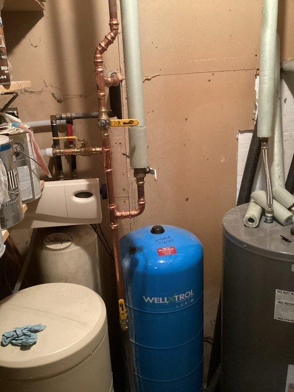 Responded to service request for a leaking water filter system. Cut out the defective filter, installed new ball valves, and completely re-piped the filter assembly to ensure proper function and prevent future leaks. Work completed at client's residence with water treatment system installed adjacent to pressure tank and water heater.