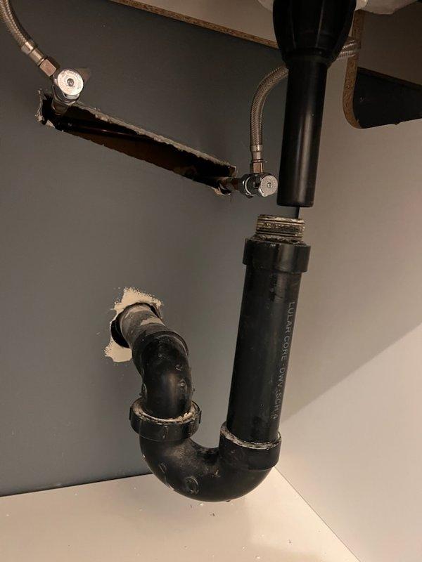 Completed installation of new P-trap assembly and supply lines for bathroom vanity sink during home remodel. Configured black PVC P-trap with proper connections to existing drain line and installed braided metal supply lines to support new faucet hardware. Final inspection confirmed proper drainage and no leaks.