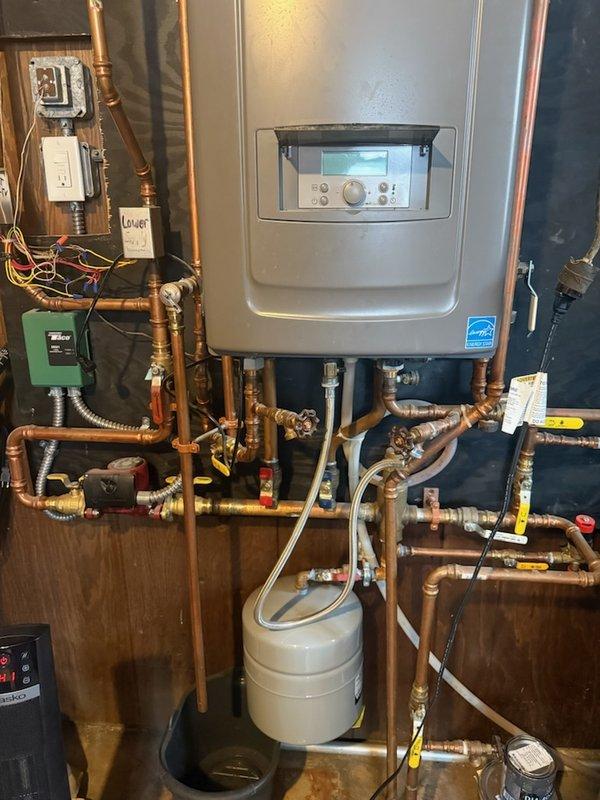 Conducted diagnostic inspection of residential water heating system with Rheem tankless water heater and customer-installed expansion tank. Identified active leak at T&P valve occurring upon water activation due to pressure issues. Also noted potential installation error where customer directed water into incorrect tankless heater inlet. Recommended transfer to HVAC technician with boiler expertise as system requires specialized repairs beyond standard plumbing scope.