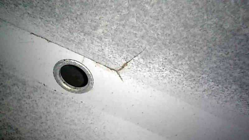 Performed routine furnace tune-up on 10-2 unit of unknown age. Inspection revealed crack in heat exchanger's center cell approximately halfway up above the eyelet, and rusting combustion blower tabs requiring future replacement. Tagged out furnace with advisory letter while maintaining operational status. Documented damage with photos showing the cracked heat exchanger and corrosion on the blower assembly. Provided customer with repair versus replacement options.