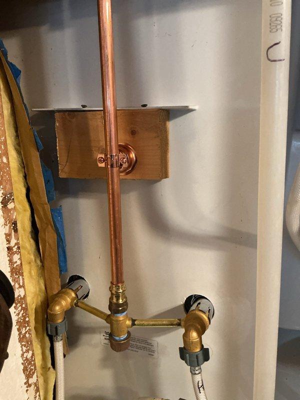 Replaced outdated two-handle shower valve with new Moen chrome model. Installed complete valve assembly with proper copper and brass connections, ensuring secure mounting to wall structure. Reconnected shower head and verified system functionality after installation.
