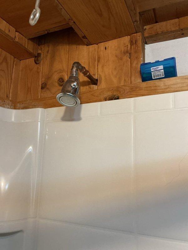 Replaced outdated two-handle shower valve with new Moen chrome model. Installed complete valve assembly with proper copper and brass connections, ensuring secure mounting to wall structure. Reconnected shower head and verified system functionality after installation.