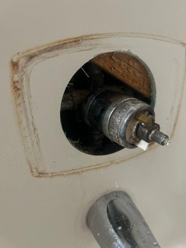 Responded to emergency call for shower valve leaking extensively into bathroom and basement. Upon inspection, discovered customer's DIY cartridge replacement attempt resulted in faucet broken off inside wall. Accessed plumbing through wall cutout, removed pedestal for proper access, and replaced damaged shower valve and trim assembly to restore proper functionality and eliminate leaks.
