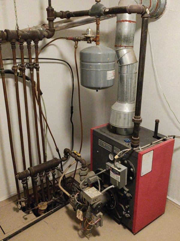 Responded to carbon monoxide alarm issue caused by backdrafting of 20-year-old gas boiler. Inspected venting system and chimney, finding possible restriction at flu cap with icicle formation. Determined unit operates effectively with additional combustion air. Recommended chimney specialist evaluation, potential flu liner installation, and future consideration of replacing aging unit with a condensing boiler.