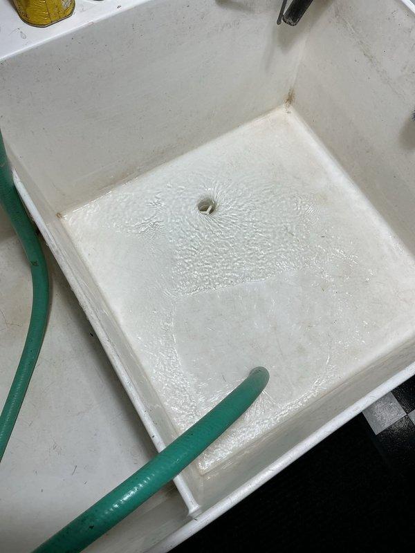 Responded to service call for slow-draining laundry tub. Upon inspection, identified clog in drainage system with evidence of significant corrosion in the brass p-trap section. Performed drain clearing service, removing debris that had accumulated in the plumbing system, and successfully restored proper drainage function to the utility sink.