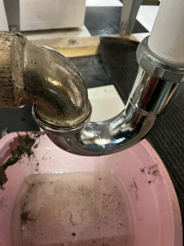 Responded to service call for slow-draining laundry tub. Upon inspection, identified clog in drainage system with evidence of significant corrosion in the brass p-trap section. Performed drain clearing service, removing debris that had accumulated in the plumbing system, and successfully restored proper drainage function to the utility sink.