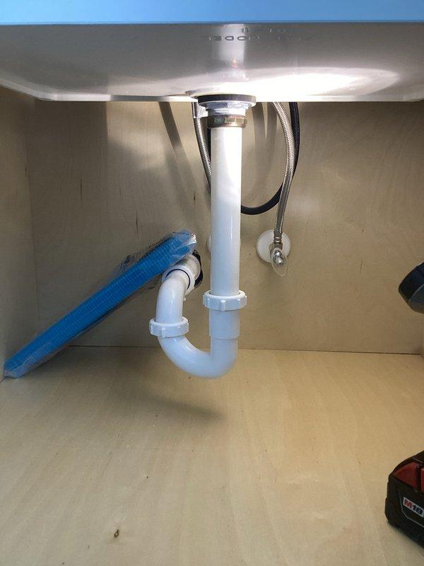 Responded to service call for a broken plastic strainer in a laundry tub that was leaking at the base. Upon inspection, found the fiberglass laundry tub sink damaged beyond repair at its base. Replaced the entire laundry basket assembly with new components and verified proper drainage with no leaks before completing the job.