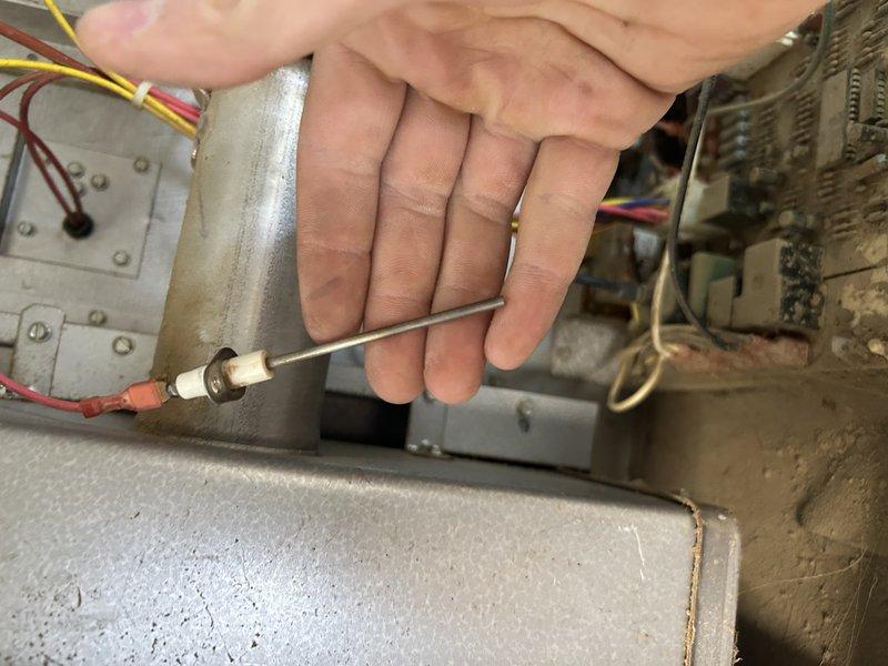 Diagnosed unit failure in barn heater due to severe heat exchanger deterioration. Observed significant corrosion with multiple holes in the header pipe and cracking eyelets causing flame extinguishment when blower activates. Performed temperature diagnostics and determined replacement of the hanging heater is required due to unsafe operating condition.