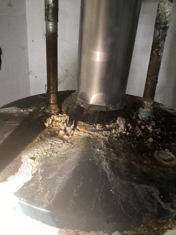 Performed inspection of two water heaters at Units A & B. First unit showed active leaking from top connections with significant corrosion and mineral buildup on copper pipes, moisture damage at base, and deterioration around floor connection points. Second unit (Richmond Integra model) appeared functional but was evaluated for replacement. Provided customer with replacement options and recommendations for both water heaters.