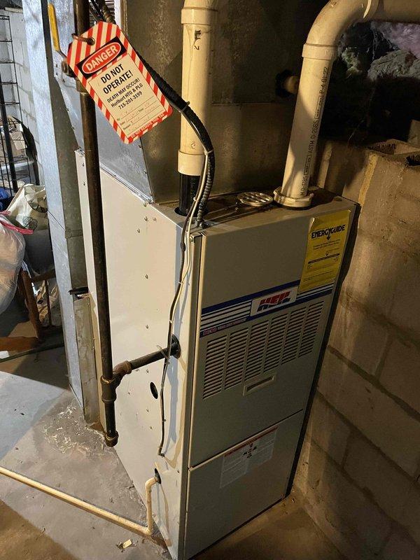 Responded to no heat call for aging furnace (10+ years). Inspection revealed a severely cracked heat exchanger with flames rolling back upon blower activation and a large hole in the secondary header box. Unit was immediately tagged out of service as unsafe to operate due to carbon monoxide hazard. Customer advised that complete furnace replacement is required.
