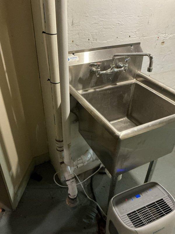 Successfully relocated utility laundry sink approximately 3 feet to accommodate customer's refrigerator and countertop installation. Reconfigured exposed PEX water lines, PVC drain, and vent piping to new location with proper connections. Verified functionality after installation with no leaks.