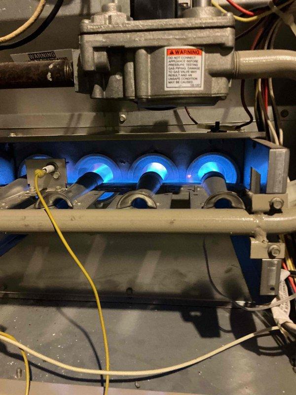 Diagnosed 26-year-old Lennox furnace with intermittent heating issues. Found weak flame sensor which was cleaned to restore ignition, but subsequently identified severe burning damage around the blower relay and wiring on the SureLight control board. Visual inspection of burner assembly showed proper combustion with blue flames, however blower motor failed to activate. Recommended replacement parts due to age of unit and potential board/blower motor failure.