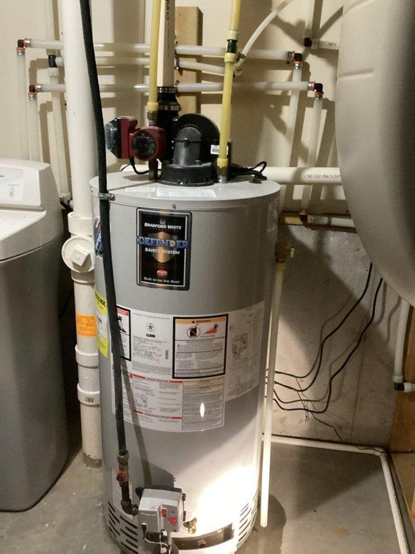 Responded to call for 10-year-old water heater leaking in utility room. Upon inspection, confirmed tank failure causing periodic water spots on floor. Removed failed unit and installed new Defender water heater, complete with proper gas line connections, PVC venting, and copper water line fittings. All connections tested for leaks and proper operation before completion.